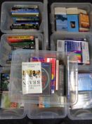 Eight plastic storage boxes with lids containing assorted books