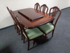 A Regency style inlaid mahogany extending dining table with leaf on brass capped feet together with