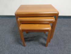 A nest of three tables in a teak finish