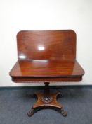 A William IV mahogany turnover top pedestal tea table on paw feet