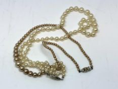 A pearl necklace with white gold clasp set with a small diamond,