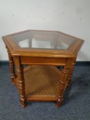 A hexagonal glass topped occasional table