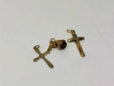 Two antique crucifix pendants together with a further charm