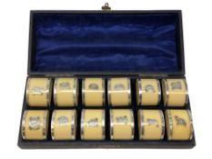 A set of twelve Victorian ivorine and silver mounted napkin rings, William Henry Jackson,