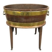 A George III mahogany brass bound cellarette with lion mask handles, on stand with wooden castors,