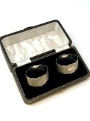 A boxed pair of oval silver napkin rings with engine turned decoration,