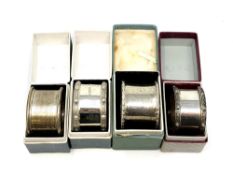 Four boxed silver napkin rings including two Lindisfarne pattern