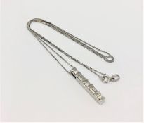 A 14ct white gold pendant and chain set with round and tapered diamonds, approx. 0.