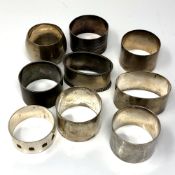 Nine heavy gauge silver serviette rings, 307g.