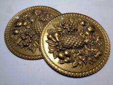 A pair of brass embossed plaques with fruit decoration