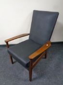 A mid 20th century teak armchair upholstered in black vinyl