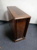 A pair of carved oak brown leather upholstered dining chairs together with an oak drop leaf table