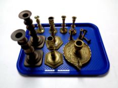 A tray containing a quantity of antique and later brass candlesticks