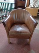 A brown leather tub chair