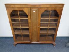 A 20th century walnut double door bookcase on raised legs