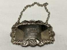 A silver decanter label,