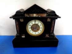 An antique black slate and marble mantel clock