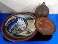 A tray containing four pieces of studio pottery to include bird of peace shallow bowl indistinctly