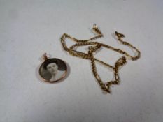 A 9ct gold chain together with a 9ct gold twin sided pendant bearing monochrome photographs