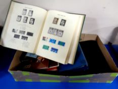 A box containing stamp albums and folders containing world stamps and first day covers together