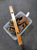 A box containing vintage woodworking tools, cast iron flat iron, spirit level,