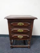 A continental oak three drawer chest with brass drop handles