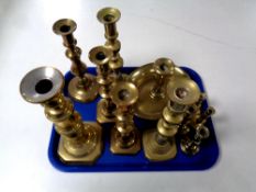 A tray of antique and later brass candlesticks
