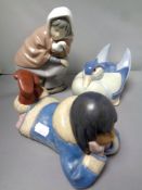 A Nao figure - Inuit child lying with head in hands, matte finish,