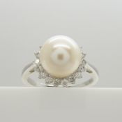 A classic-styled cultured pearl and diamond halo ring in 9ct white gold