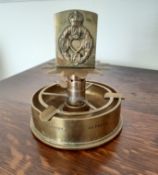 A Second World War trench ashtray bearing REME cap badge.