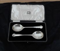 A cased pair of silver serving spoons.