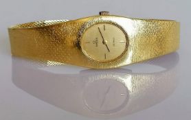 A ladies 18ct yellow gold Omega De Ville wristwatch, the rectangular case enclosing oval champagne
