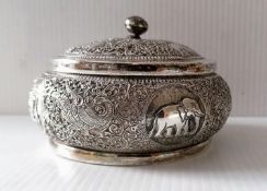 An Indian silver lidded jar with profuse embossed decoration, 7 x 11 cm diameter, with slight dents,