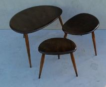 A nest of three Ercol pebble tables and matching coffee table (diam. 74 cm), all with blue labels,