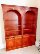 A Sheraton-style mahogany arcaded set of three open bookcases with blind fretwork to cornice and