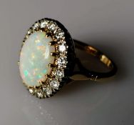 An oval opal cluster ring with sixteen round brilliant-cut diamonds, approximate total weight 1.20