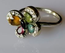 An 18ct white gold multi-gem flower ring with diamond decoration, size L, hallmarked, 4.79g