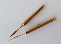 Two 9ct yellow gold tooth picks with engine turned design, each 7cm extended, hallmarked, 12.32g