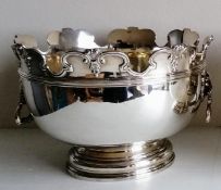 A Victorian silver monteith punch bowl with moulded rim, lion mask handles on a stepped pedestal