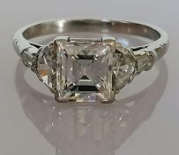 A five-stone diamond ring set with a central modified emerald-cut diamond, flanked by a fancy half-