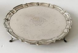 A George V silver salver with pie crust border on four hoof feet by Barker Brothers, Chester,