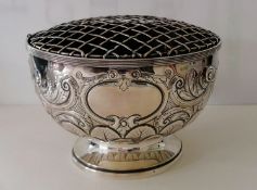 A late Victorian silver punch bowl or table centre with embossed rococo decoration on a spreading