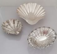 A Victorian larger silver scallop shell, another smaller with husks in relief, both on three ball
