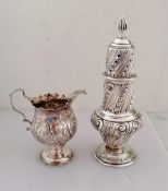 A George III silver cream jug with carved rim, embossed floral decoration, scroll handle on a raised