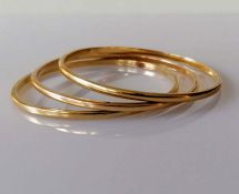 Three yellow gold bangles of plain form, unmarked, tests for 9ct, each 68mm, 40.5g