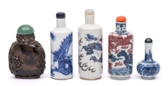 A group of four Chinese porcelain snuff bottles and stoppers and an agate snuff bottle: one painted