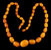 An amber bead necklace,: the graduated 30mm to 10mm amber beads on a knotted thread, 74.