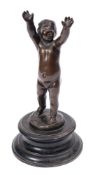 A late 19th century bronze figure of a putti: with outstretched raised arms,