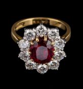 A ruby and diamond ring,: the central oval cut ruby, estimated to weigh 2.