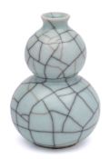WITHDRAWN A Guan type vase: of double gourd form under crazed celadon glaze, 13cm high.